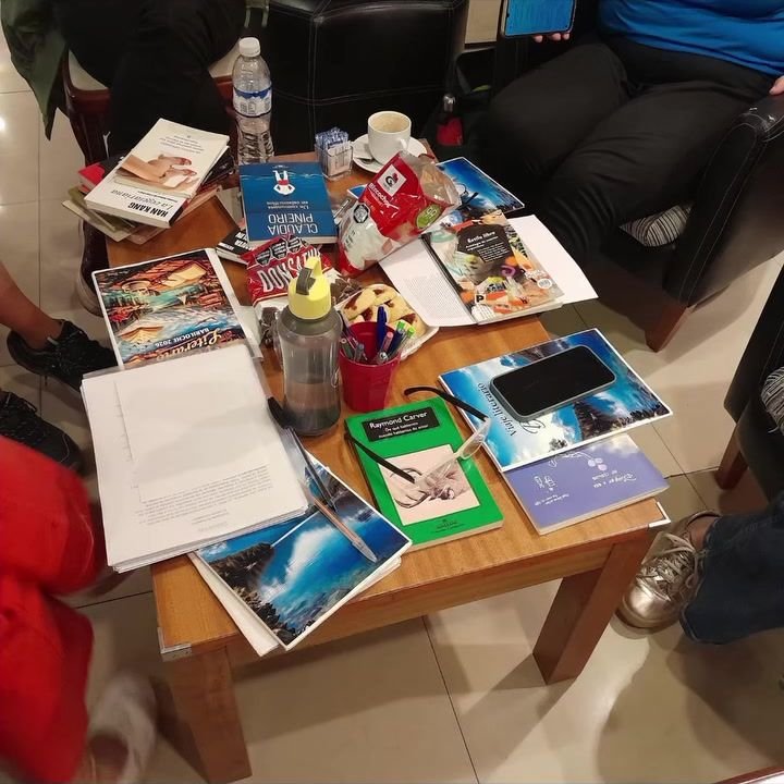 Mesa con libros, cuadernos y materiales de taller.
